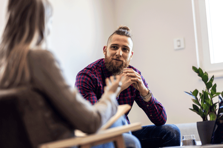 Happy person in therapy session after finding out answers to the question what is cognitive behavioral therapy