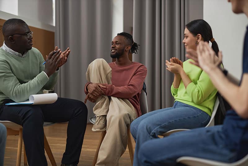 Happy people in group therapy as part of the residential treatment program at Virtue Recovery Center