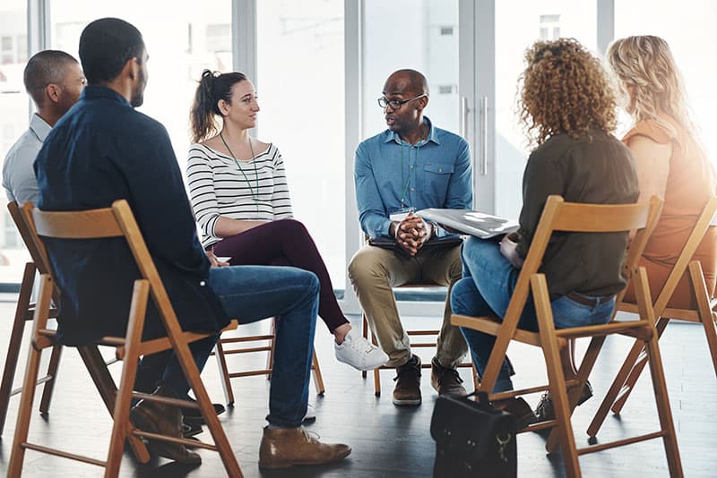 Diverse group of six people in the group therapy program at Virtue Recovery Center