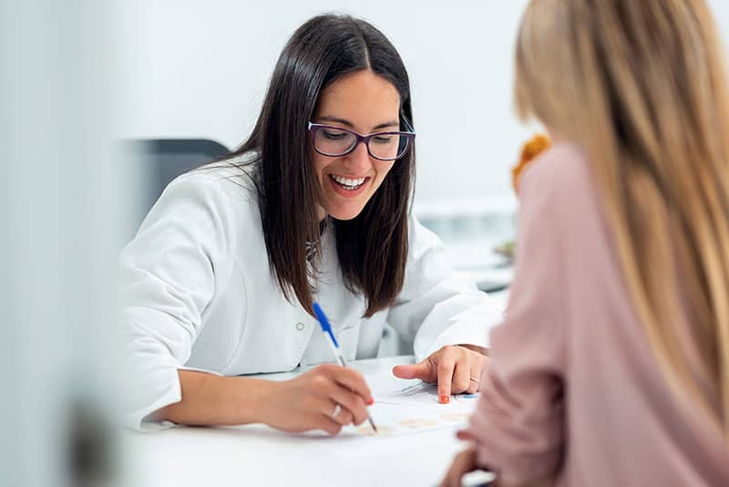 Smiling clinician helping person enroll in the outpatient treatment program at Virtue Recovery Center