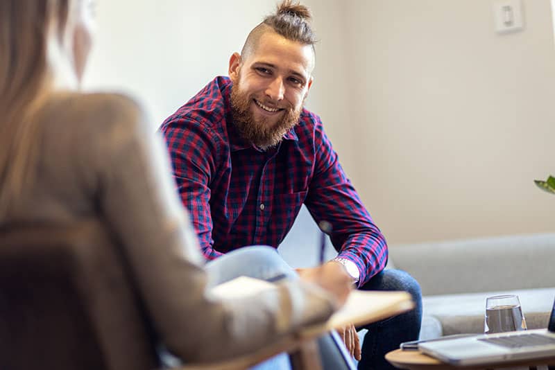 Smiling person in session with counselor in the trauma therapy program at Virtue Recovery Center