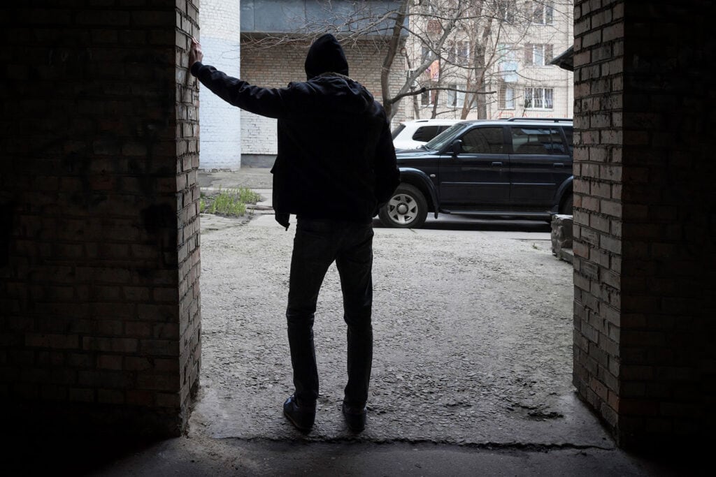 person standing in the dark leaning against wall while dealing with long term effects of cocaine