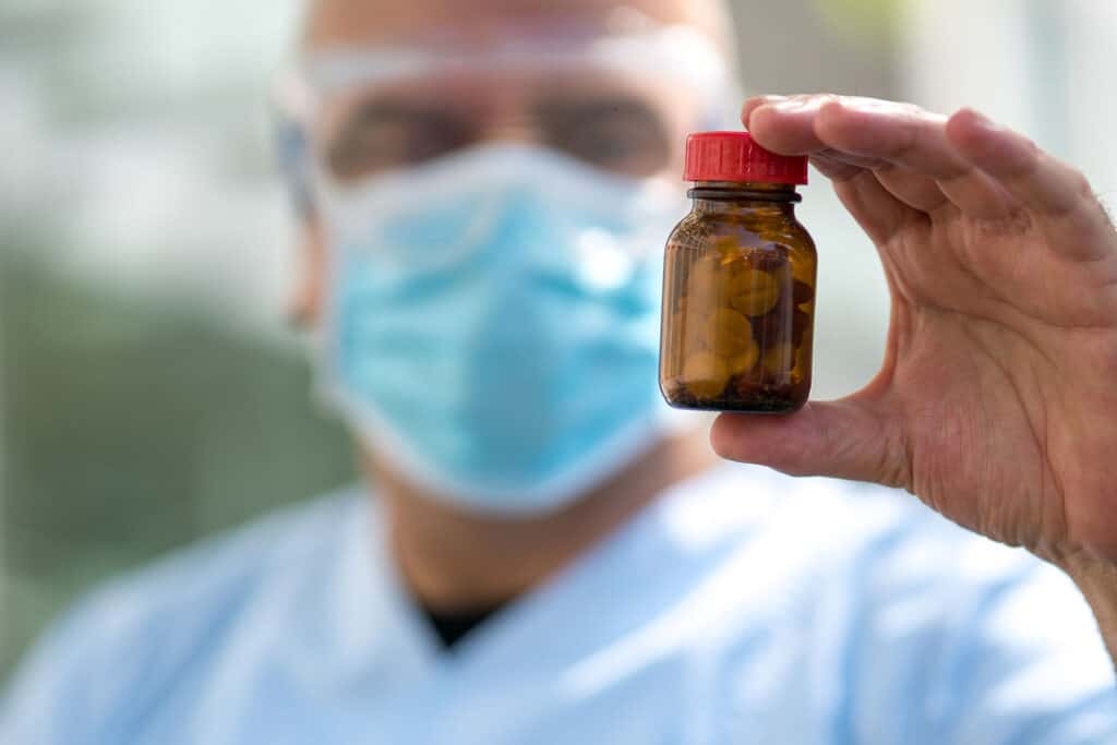 clinician holding up pill bottle to illustrate the difference between opioid vs opiate