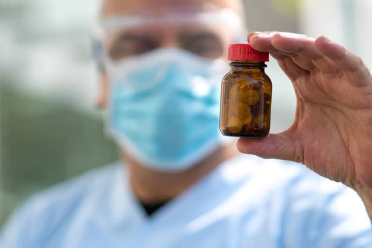 clinician holding up pill bottle to illustrate the difference between opioid vs opiate